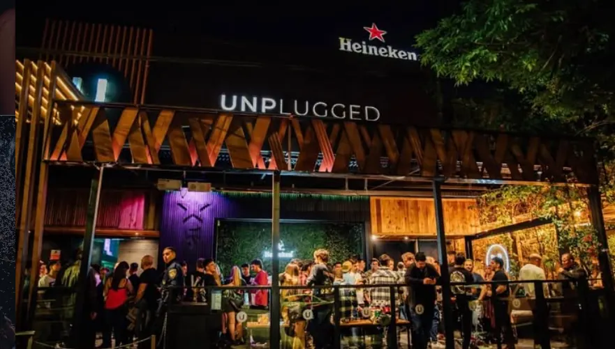 Frente de Unplugged sobre Av. Rafael Núñez, de noche y con gente en la entrada