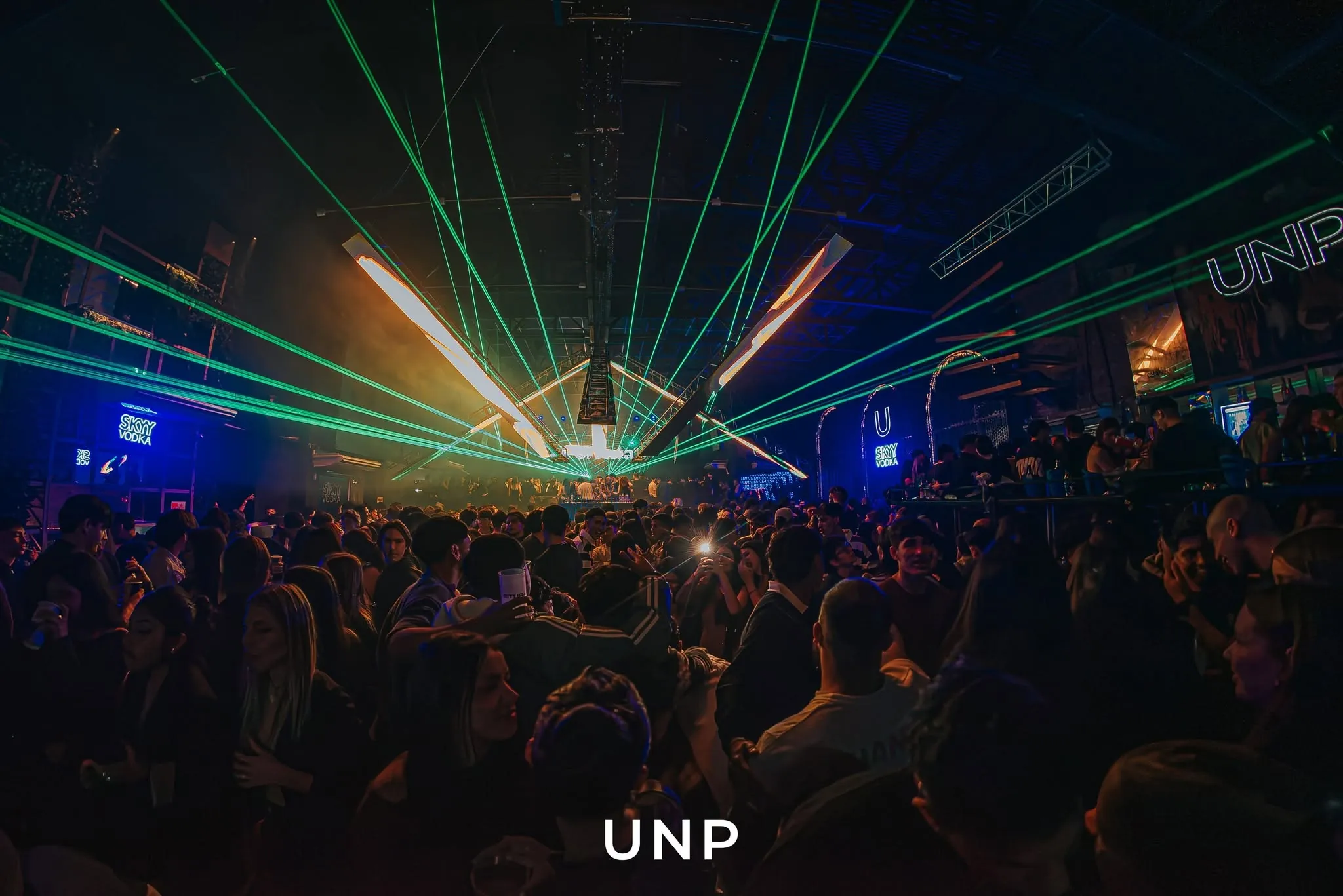 Pista de Unplugged llena, con láseres verdes sobre la gente